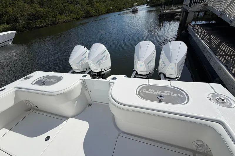 Slide: The Image of 2022 SeaHunter 38 CTS boat with four powerful outboard engines on a calm waterway. - 8