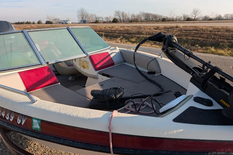 Slide: The Image of 2009 Skeeter SL1900 boat with red and white interior, parked on roadside. - 13