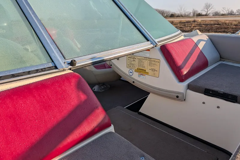 Slide: The Image of 2009 Skeeter SL1900 boat interior with red and gray seating, windshield, and safety labels. - 14