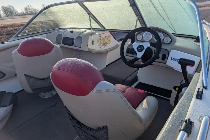 Slide: The Image of 2009 Skeeter SL1900 boat interior with red and white seats, steering wheel, and dashboard. - 15