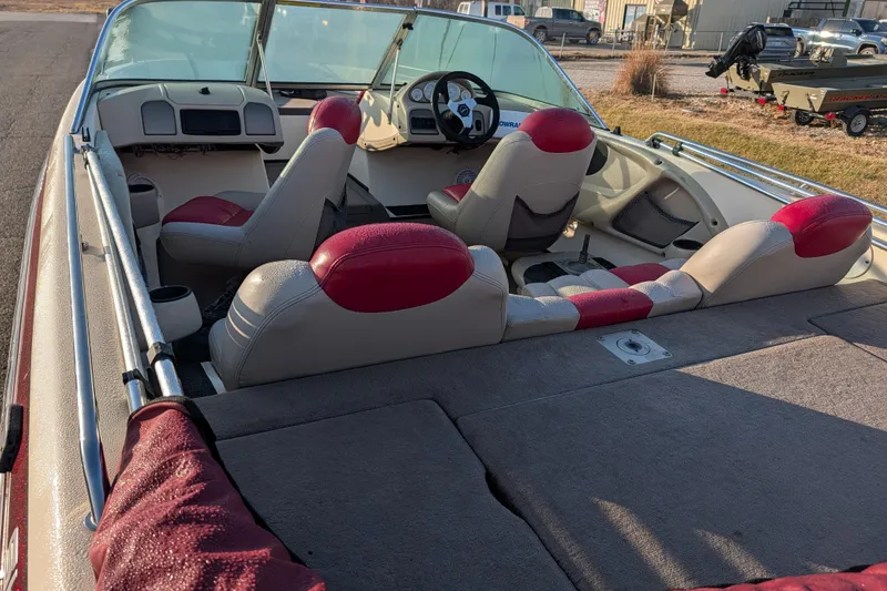 Slide: The Image of 2009 Skeeter SL1900 boat interior with red and beige seating, steering wheel, and dashboard. - 16