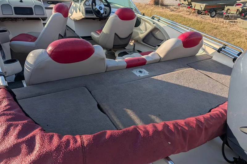 Slide: The Image of 2009 Skeeter SL1900 boat interior with red and gray seating, spacious deck, and steering console. - 19