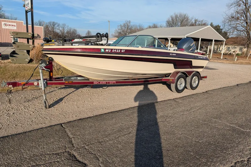 Slide: The Image of 2009 Skeeter SL1900 boat on trailer, parked outdoors on a sunny day. - 2