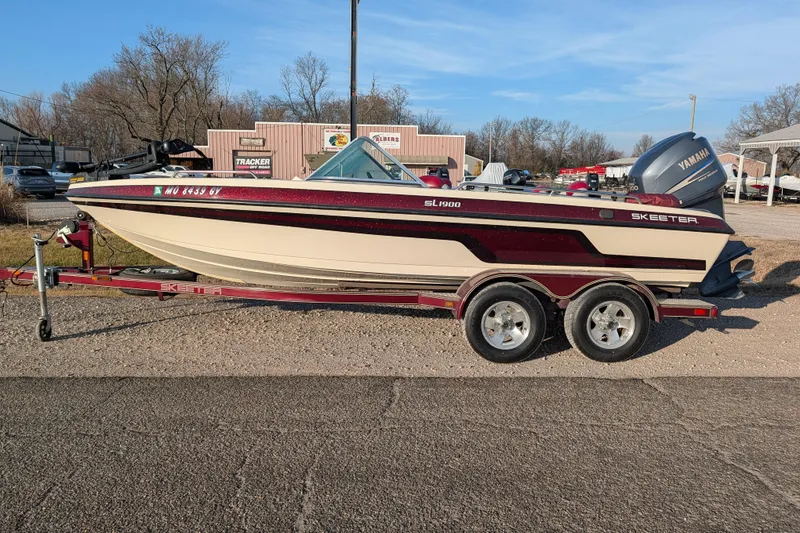 Slide: The Image of 2009 Skeeter SL1900 boat on trailer with Yamaha outboard motor, parked outdoors. - 3