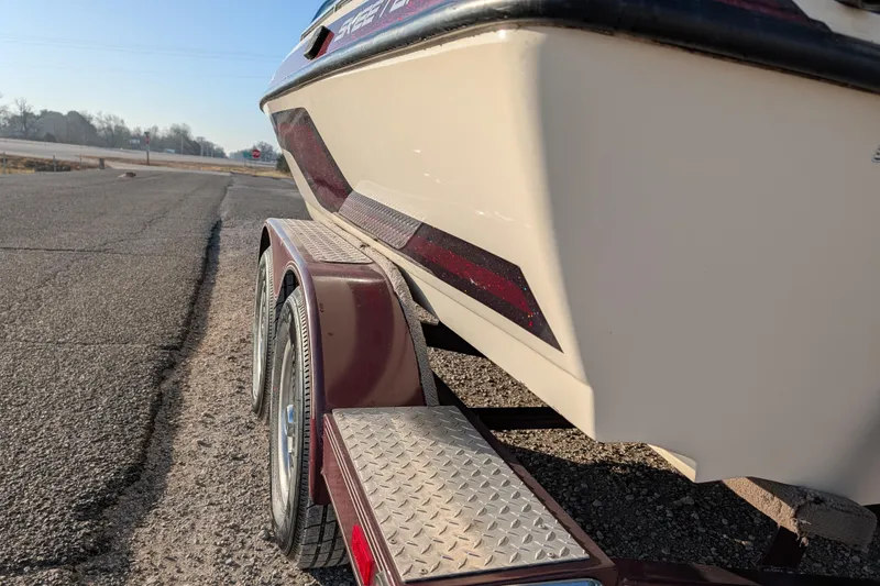 Slide: The Image of 2009 Skeeter SL1900 boat on trailer, parked on roadside under clear sky. - 5