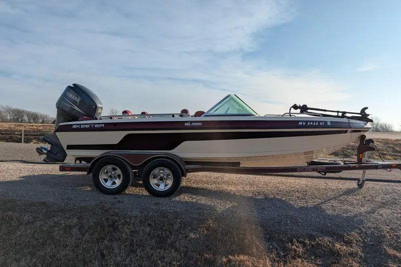 Slide: The Image of 2009 Skeeter SL1900 boat on trailer with Yamaha outboard motor, parked outdoors. - 9