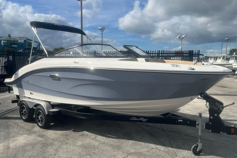 Slide: The Image of 2024 Sea Ray SPX 210 Outboard boat on trailer, parked outdoors under cloudy sky. - 10
