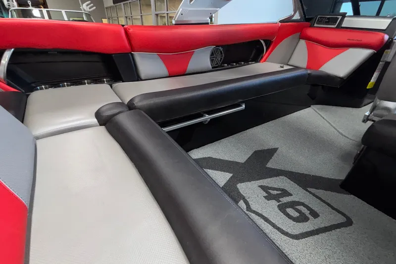 Slide: The Image of 2017 MasterCraft X46 interior with red and gray seating, featuring stylish design and logo carpet. - 20