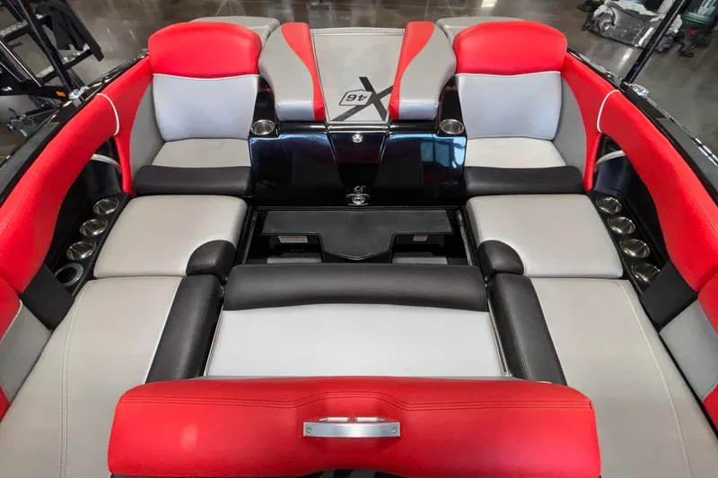 Slide: The Image of 2017 MasterCraft X46 boat interior with red and gray seating, cup holders, and sleek design. - 22