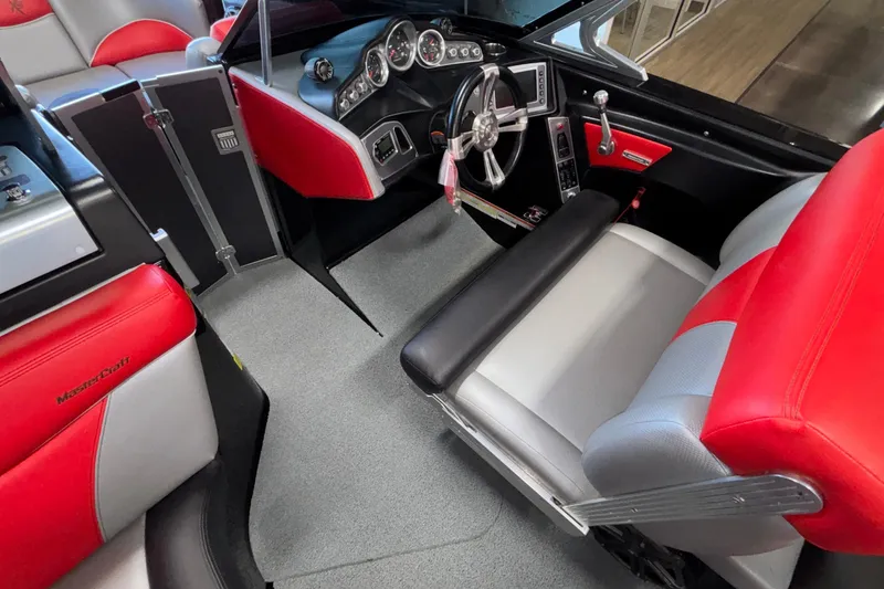 Slide: The Image of 2017 MasterCraft X46 boat interior with red and gray seating, modern dashboard, and steering wheel. - 27