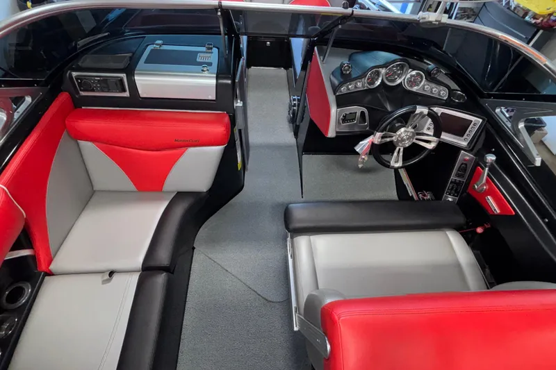 Slide: The Image of 2017 MasterCraft X46 boat interior with red and gray seating, modern dashboard, and steering wheel. - 28