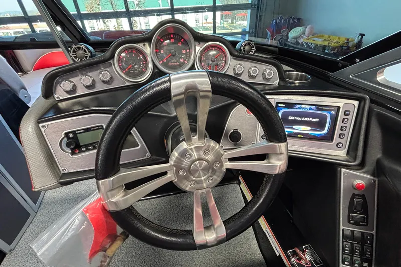 Slide: The Image of 2017 MasterCraft X46 boat dashboard with steering wheel and control panel. - 37