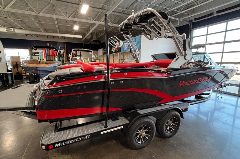 Slide: The Image of 2017 MasterCraft X46 boat with red and black design on a trailer in a showroom. - 4
