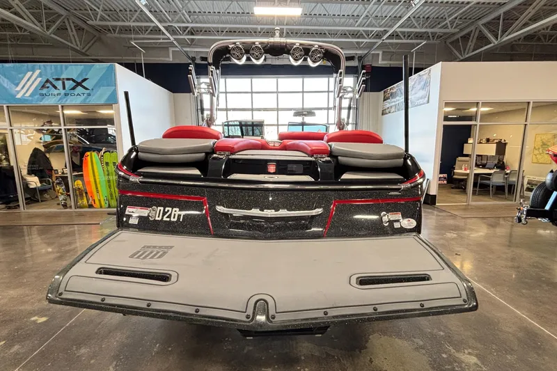 Slide: The Image of 2017 MasterCraft X46 boat in showroom, rear view with red seating and surfboards displayed. - 5
