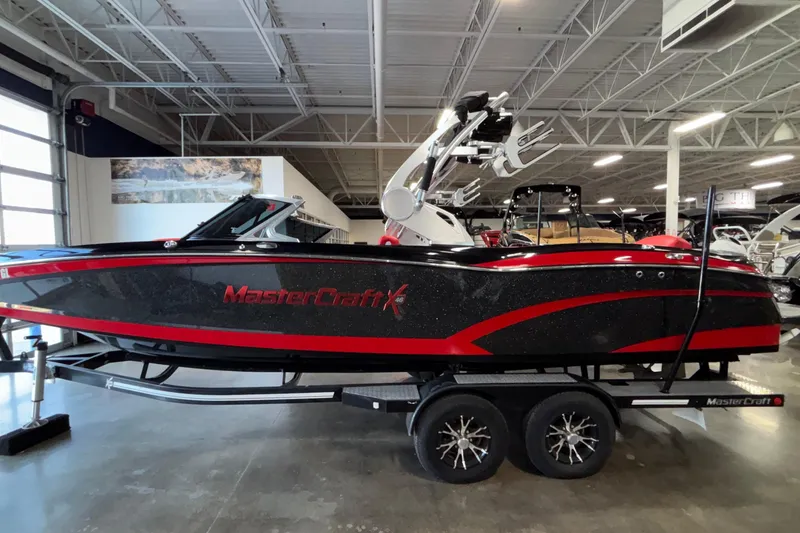 Slide: The Image of 2017 MasterCraft X46 boat in showroom, black with red accents, on trailer. - 7