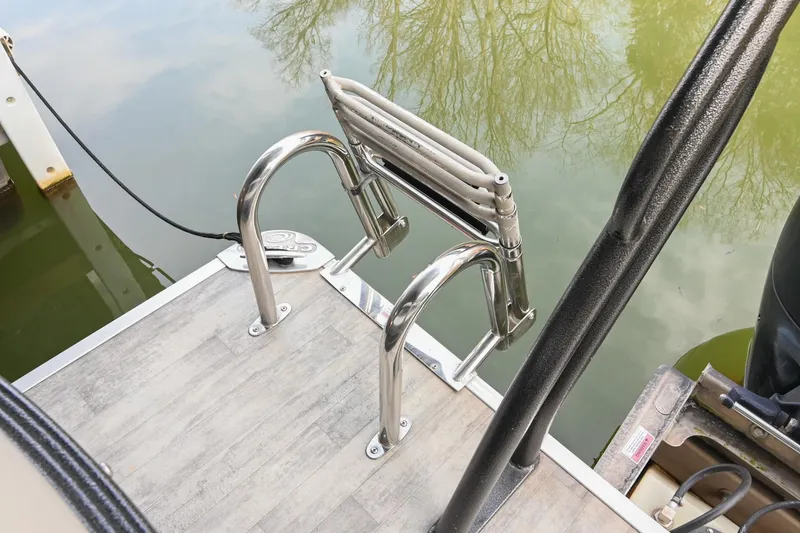 Slide: The Image of 2021 Crest Classic DLX 220 L boat ladder on deck by water. - 12