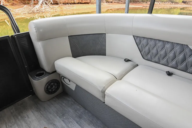 Slide: The Image of Luxurious seating on 2021 Crest Classic DLX 220 L pontoon boat, featuring elegant upholstery and speaker system. - 16