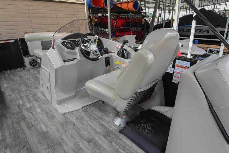 Slide: The Image of 2021 Crest Classic DLX 220 L boat interior with steering console and seating. - 24