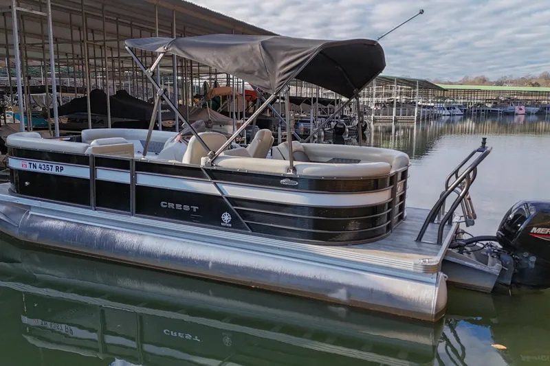 Slide: The Image of 2021 Crest Classic DLX 220 L pontoon boat docked in marina. - 3
