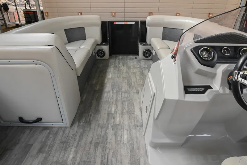 Slide: The Image of 2021 Crest Classic DLX 220 L pontoon boat interior with gray seating and modern dashboard. - 33