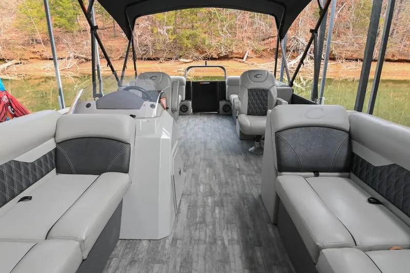 Slide: The Image of 2021 Crest Classic DLX 220 L pontoon boat interior with gray seating and wood-style flooring. - 9