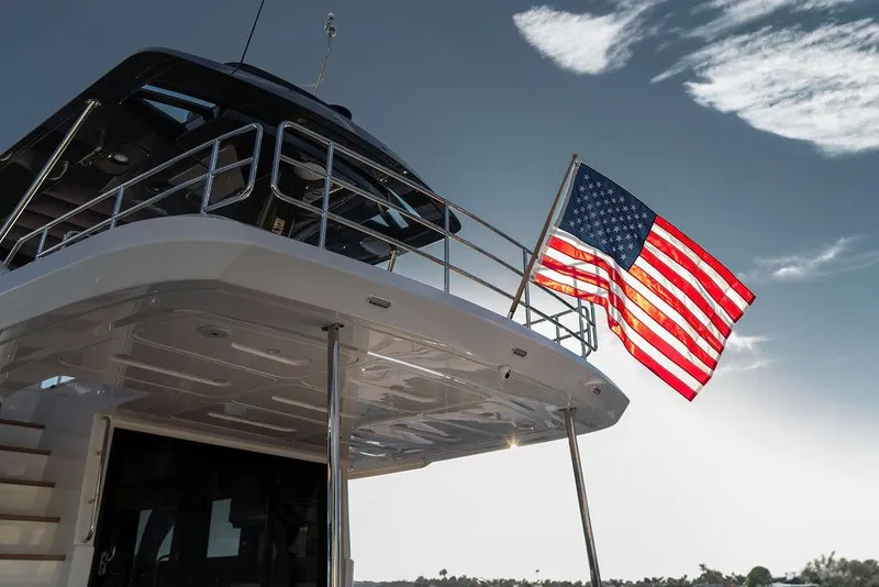Slide: The Image of 2023 Pardo Yachts Endurance 60 with American flag, sleek design under clear sky. - 41