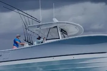 Slide: The Image of 2026 Regulator 26XO boat on water, two people onboard, fishing rods visible. - 1