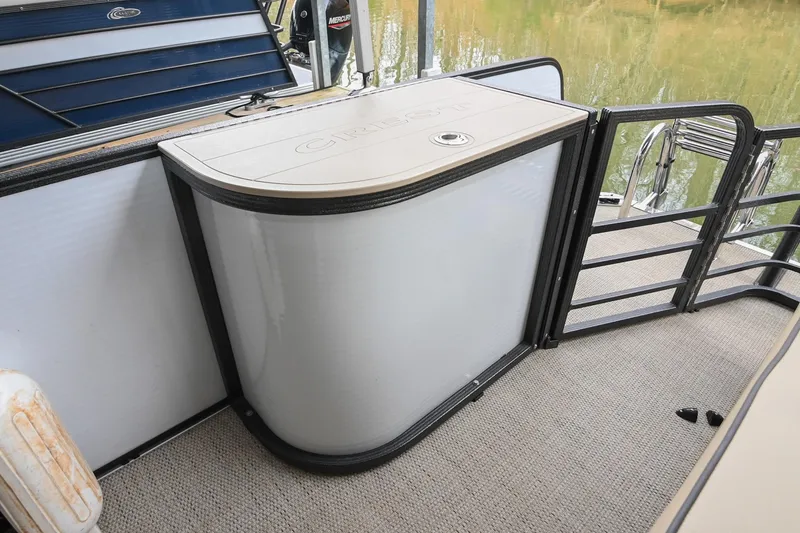 Slide: The Image of 2022 Crest Classic DLX 220 boat interior with storage compartment and railing. - 13