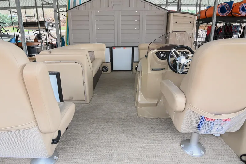 Slide: The Image of 2022 Crest Classic DLX 220 boat interior with beige seating and steering console. - 16