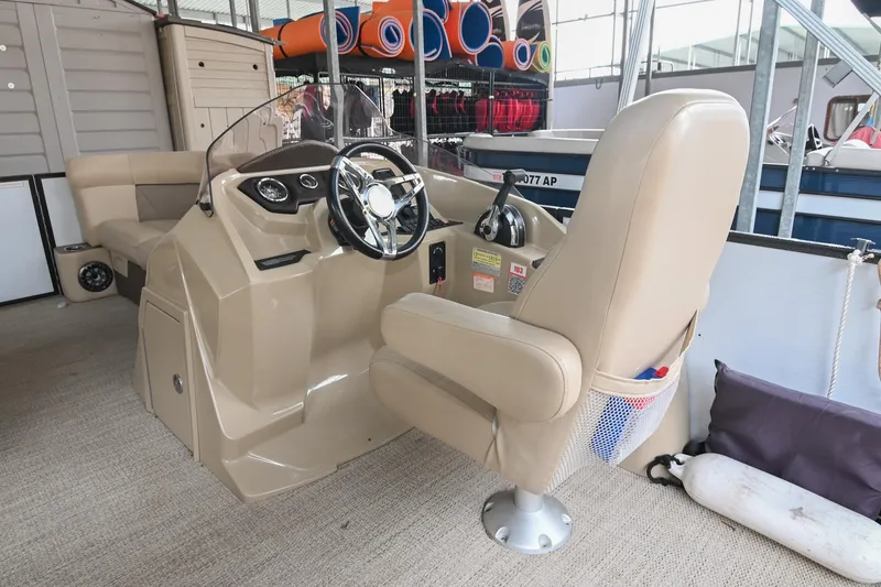 Slide: The Image of 2022 Crest Classic DLX 220 boat interior with beige captain's chair and steering console. - 19