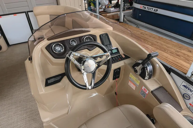 Slide: The Image of 2022 Crest Classic DLX 220 boat dashboard with steering wheel and controls. - 21