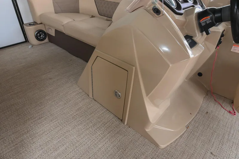 Slide: The Image of Interior of 2022 Crest Classic DLX 220 boat with beige seating and control panel. - 26