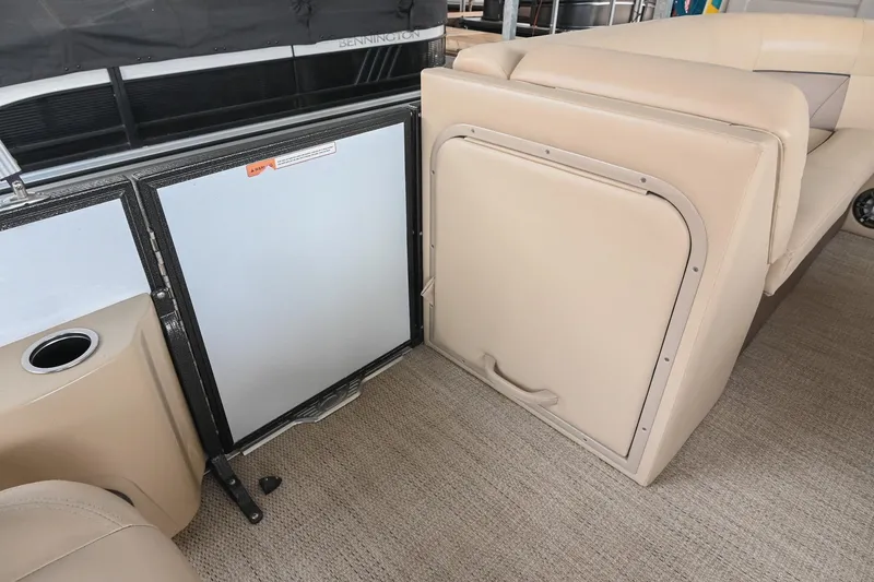 Slide: The Image of Interior of 2022 Crest Classic DLX 220 boat with beige seating and storage compartment. - 27