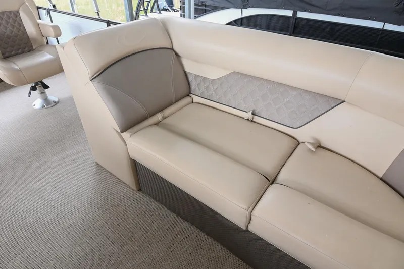 Slide: The Image of 2022 Crest Classic DLX 220 boat interior with beige seating and quilted accents. - 30