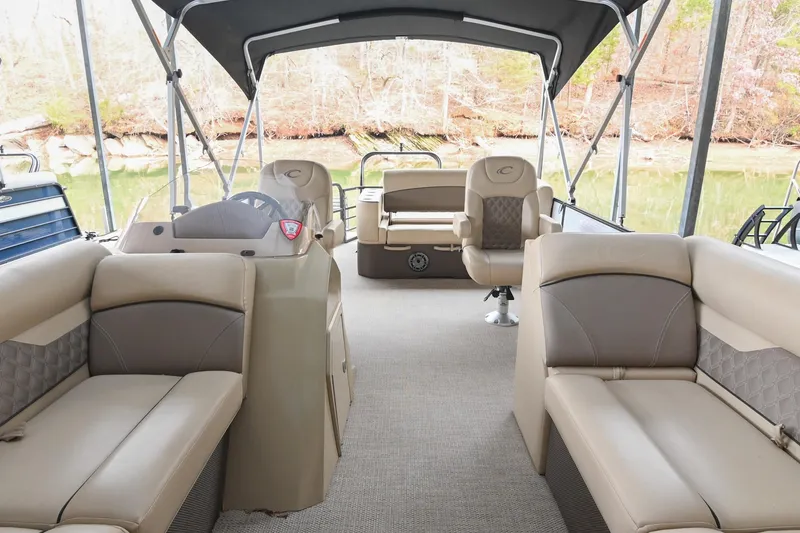 Slide: The Image of 2022 Crest Classic DLX 220 pontoon boat interior with beige seating and canopy. - 6