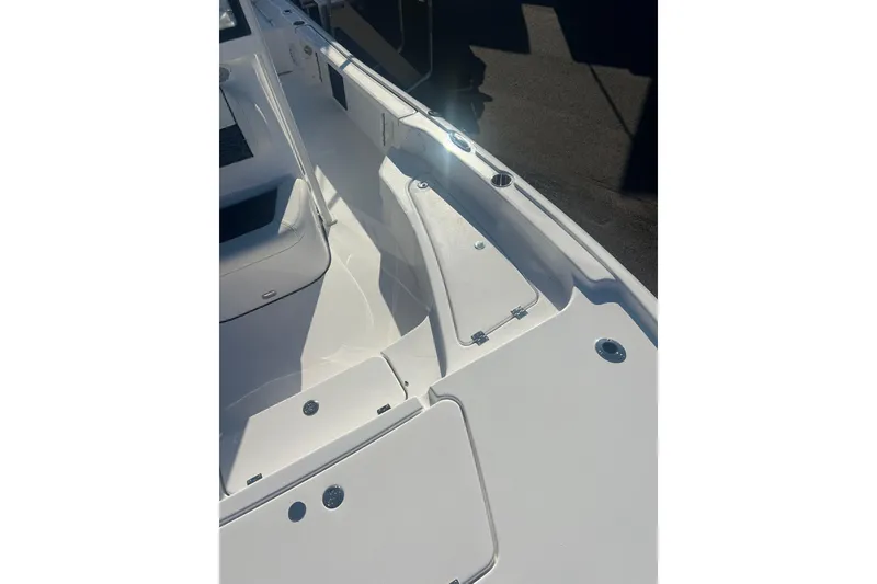 Slide: The Image of 2026 Tidewater 2210 Carolina Bay boat interior with sleek white seating and storage compartments. - 15
