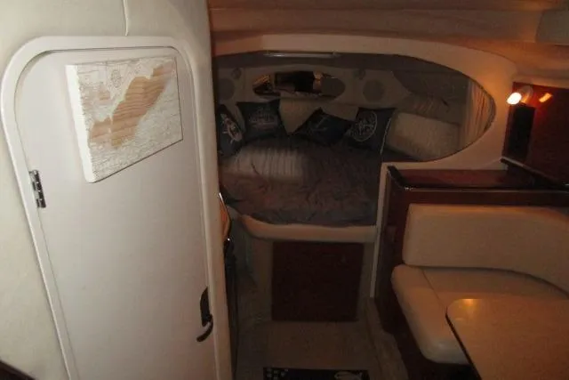 Slide: The Image of 2005 Sea Ray 290 Amberjack cabin interior with cozy bed and seating area. - 11