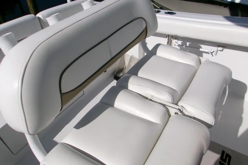 Slide: The Image of 2014 Sportsman Heritage 241 Center Console boat with white cushioned seating. - 15