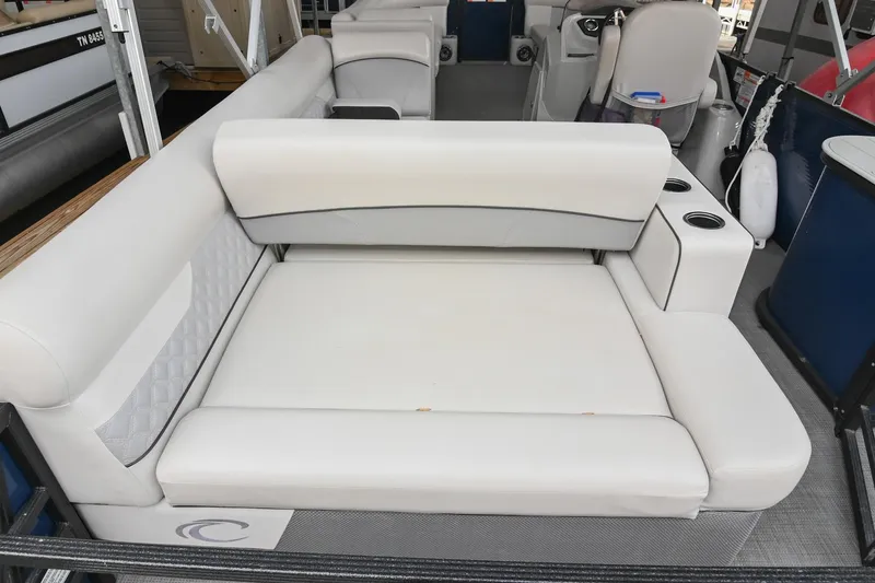 Slide: The Image of 2022 Crest Classic DLX 220 boat interior with white cushioned seating and cup holders. - 10