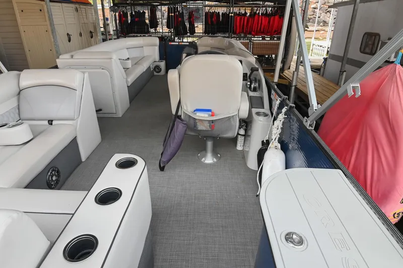 Slide: The Image of 2022 Crest Classic DLX 220 pontoon boat interior with seating and storage compartments. - 13