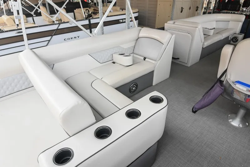 Slide: The Image of 2022 Crest Classic DLX 220 boat interior with white seating and cup holders. - 14