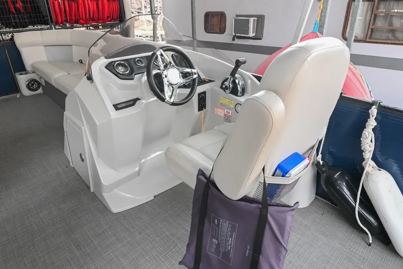 Slide: The Image of 2022 Crest Classic DLX 220 boat interior with steering wheel and seating area. - 20