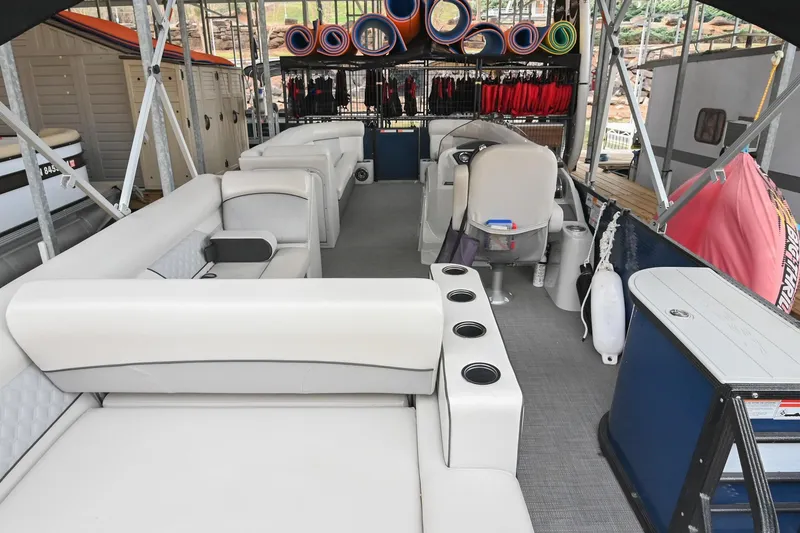 Slide: The Image of 2022 Crest Classic DLX 220 pontoon boat interior with seating and storage. - 5