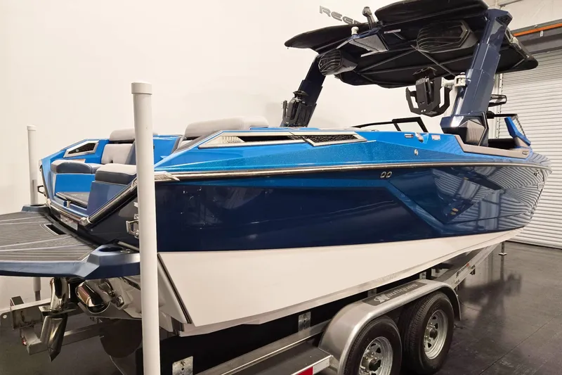 Slide: The Image of 2022 Nautique Super Air Nautique G25 Paragon boat in showroom, blue and white exterior. - 3