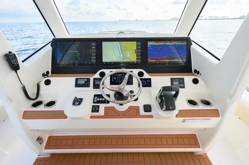 Slide: The Image of 2022 SeaVee 450Z helm with advanced navigation displays and controls on open water. - 12