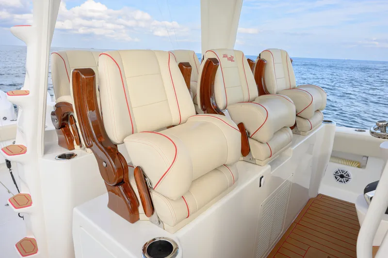 Slide: The Image of Luxurious seating on 2022 SeaVee 450Z boat, featuring plush cream cushions and wooden accents. - 14