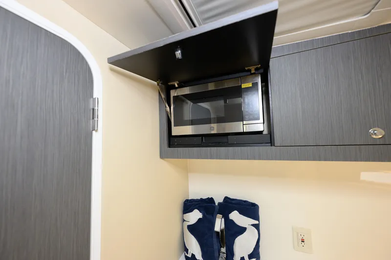 Slide: The Image of 2022 SeaVee 450Z interior with microwave and stylish cabinetry. - 20