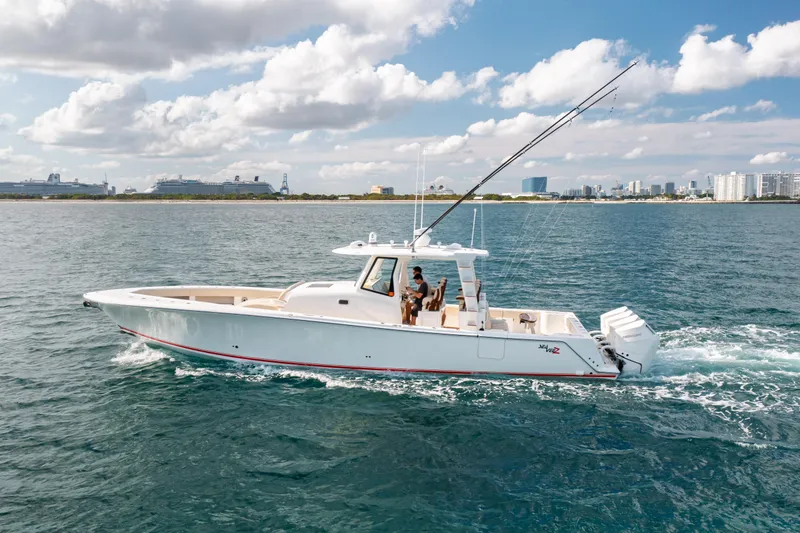 Slide: The Image of 2022 SeaVee 450Z boat cruising on open water with city skyline in background. - 3