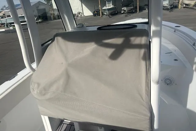 Slide: The Image of 2024 Sea Hunt Ultra 239 SE boat console with protective cover in a marina setting. - 7