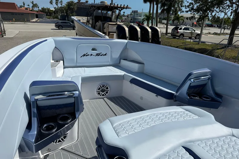 The Image of 2024 Nor-Tech 340 Sport Center Console boat interior with seating and cup holders. - 1